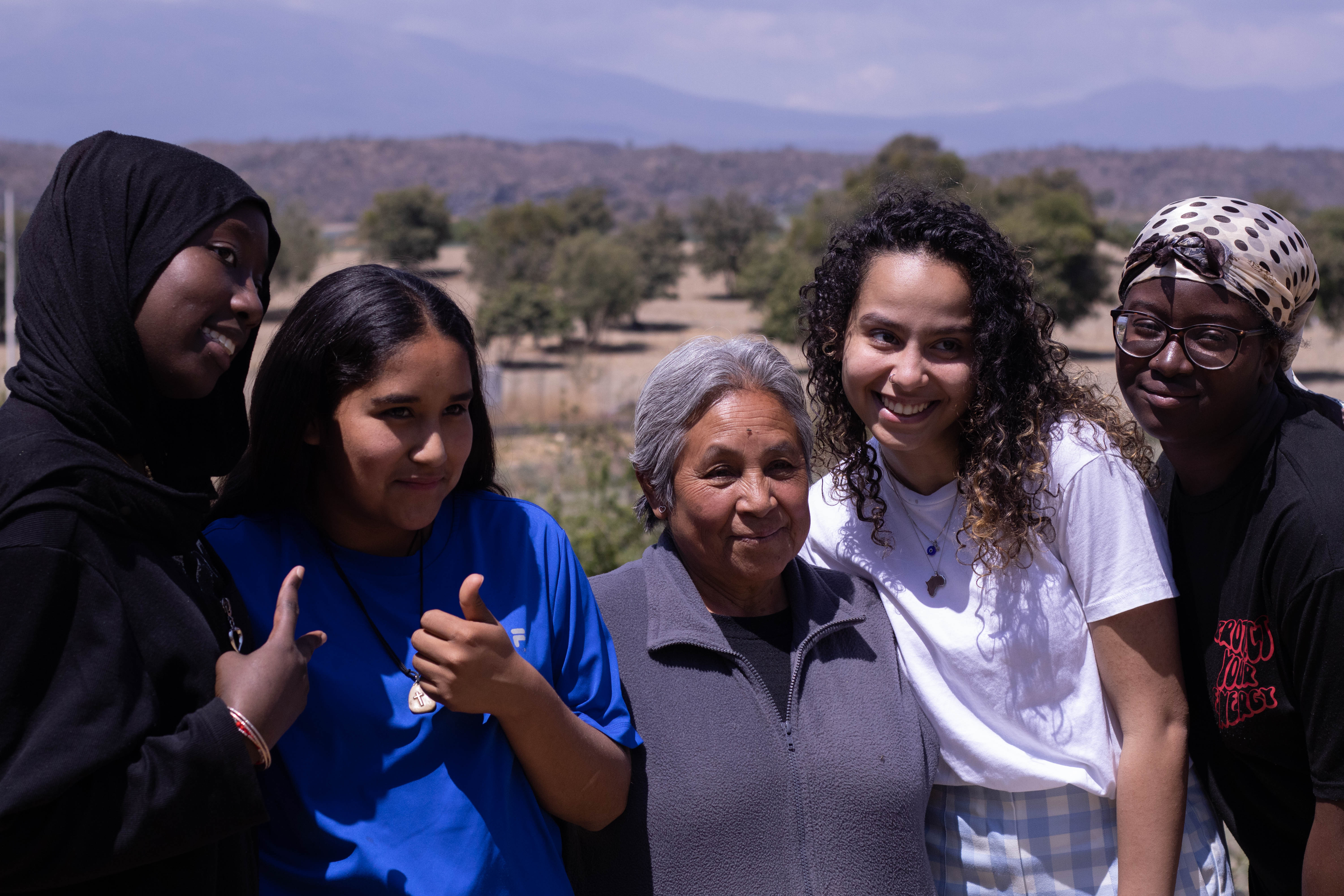 Volunteers and a community elder smiling together outdoors